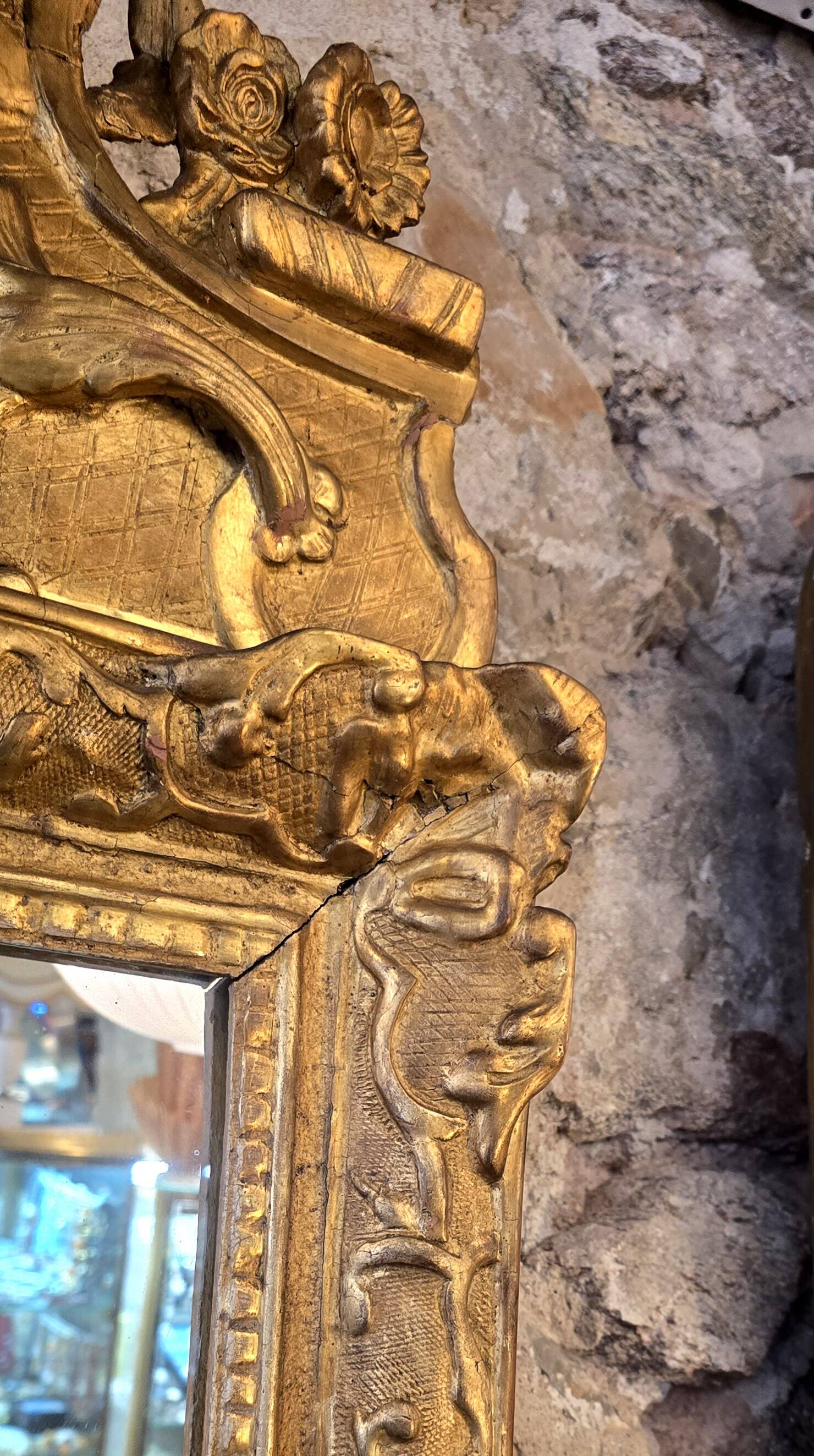 Miroir d’époque Régence à fronton en bois sculpté et doré  – XVIIIe