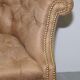 Chesterfield armchair in hardwood, leather, and woven linen.