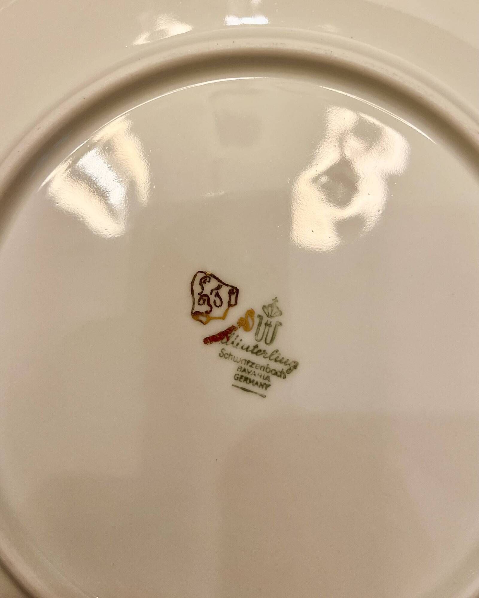 24 plates and a vintage porcelain dish decorated by Lucien Engel.