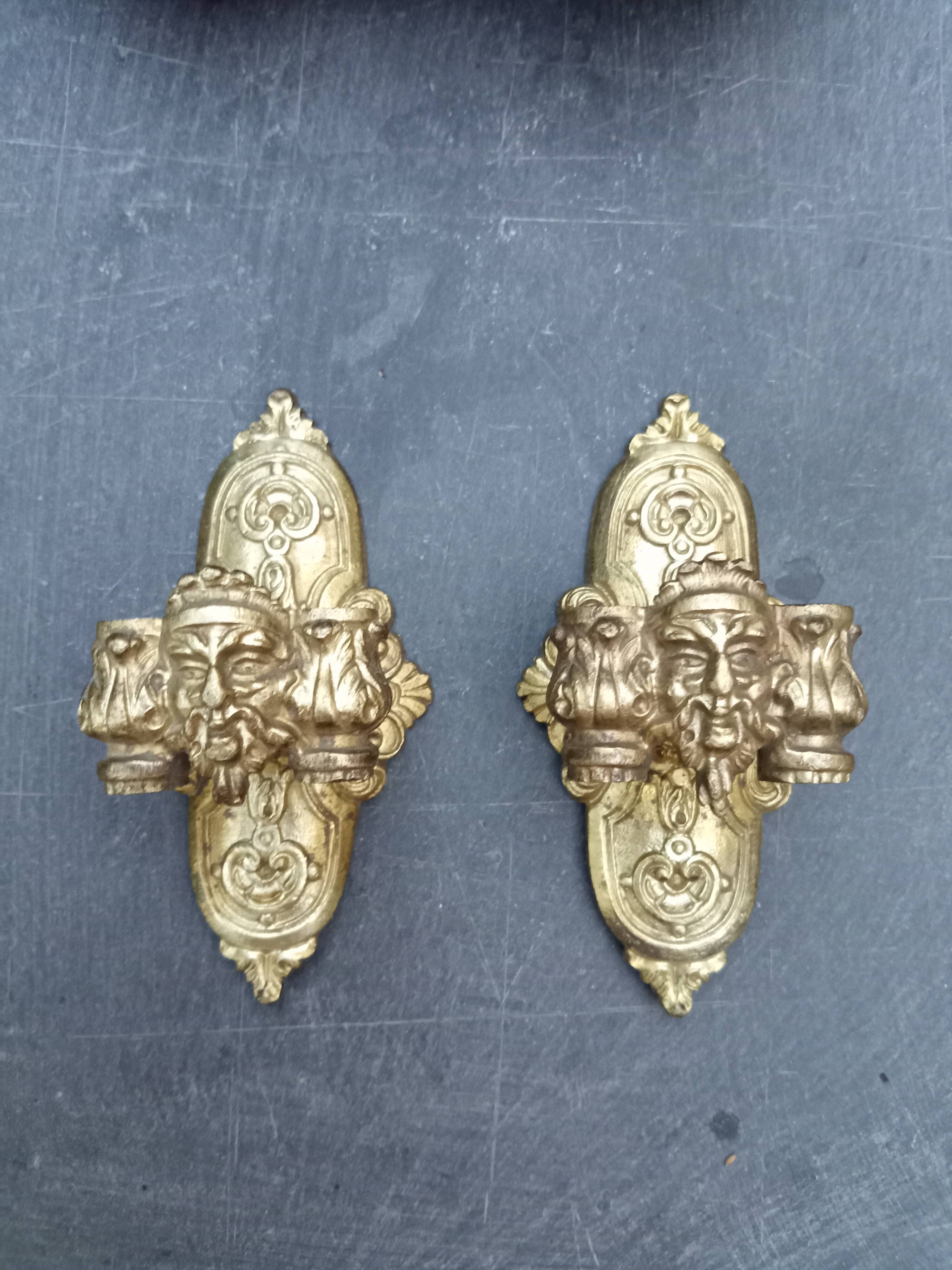 Pair of bronze wall sconces with mask, signed L. Pinet, Art Nouveau period.