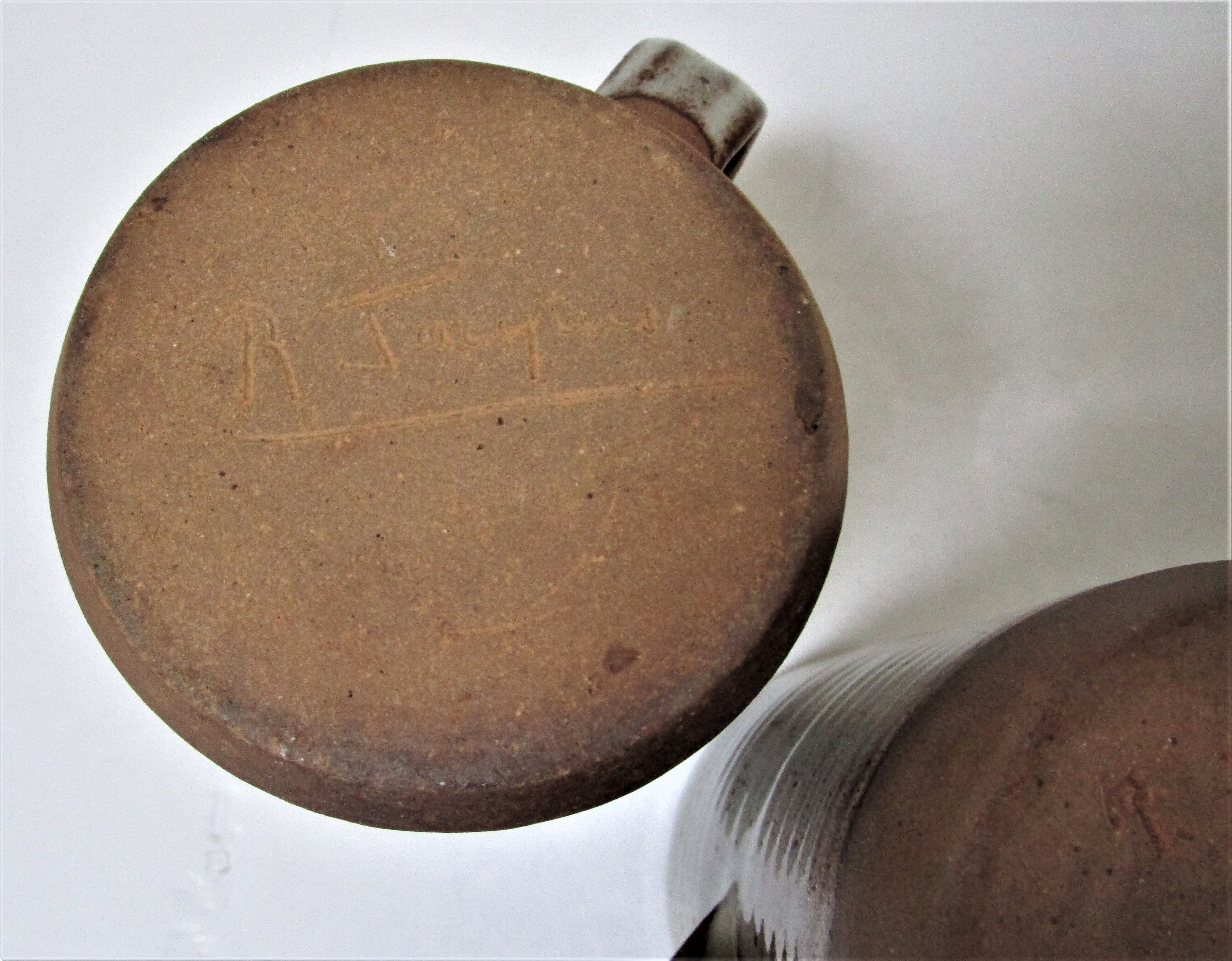 Two enamelled sandstone mugs Roger Jacques handwritten signature