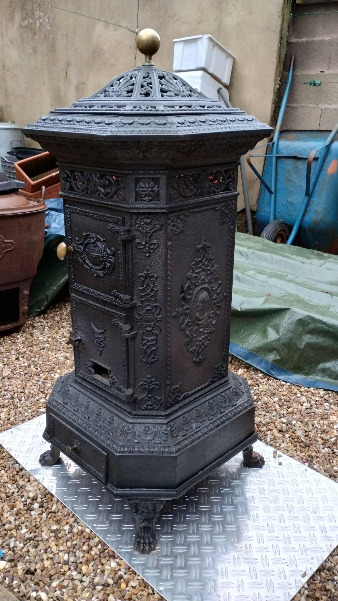 Black cast iron wood burning stove with solid brass handle.