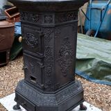 Black cast iron wood burning stove with solid brass handle.