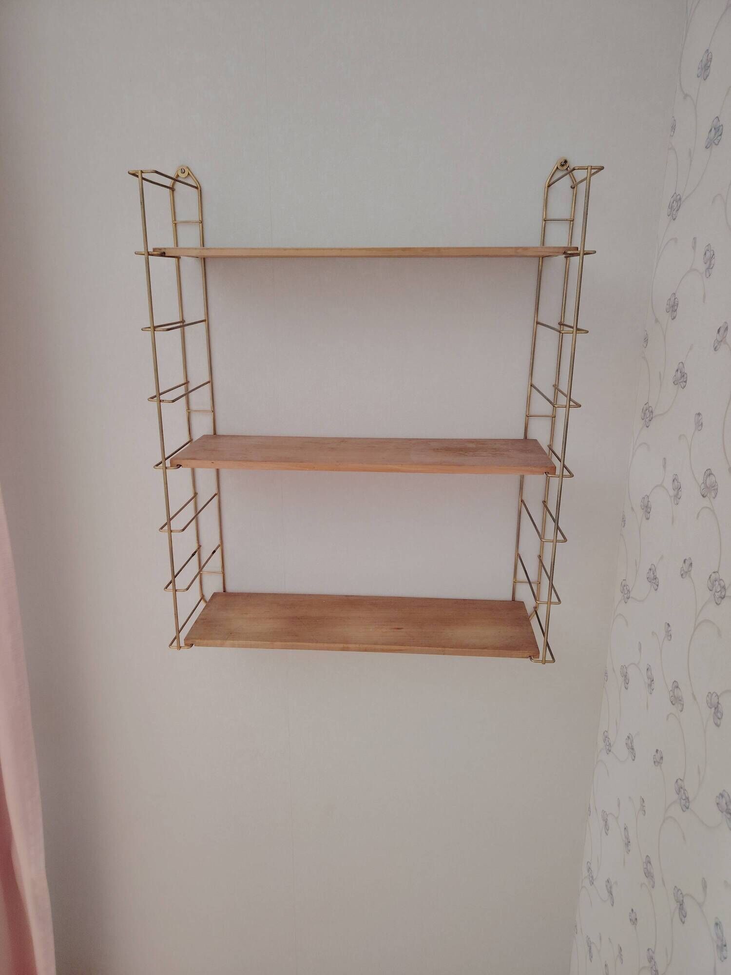 Vintage modular wall shelf in golden steel wire and wood from the 1950s.