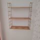 Vintage modular wall shelf in golden steel wire and wood from the 1950s.