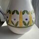 Large white terracotta carafe with a stylized green and yellow frieze pattern