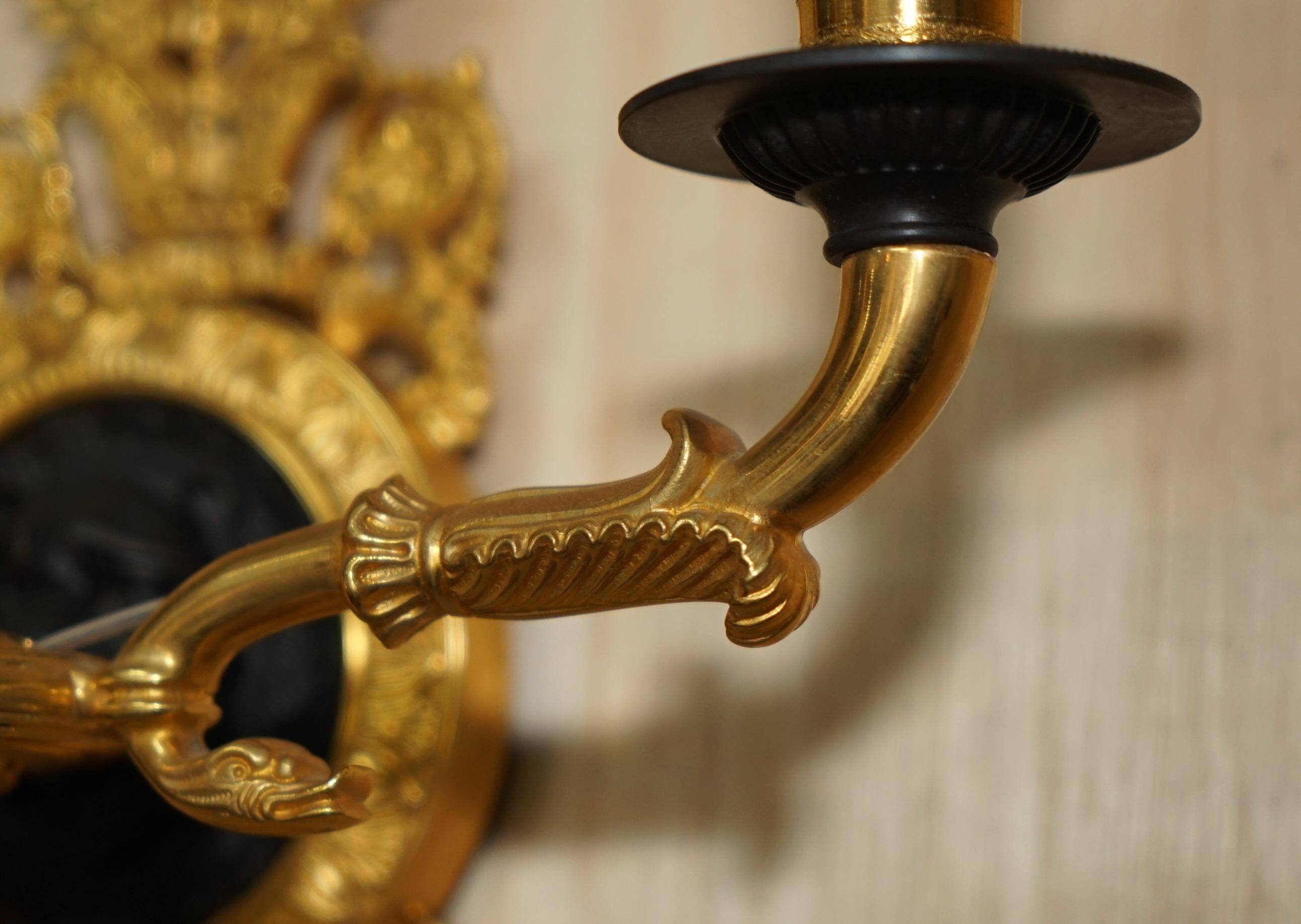 Pair of L'Originale wall sconces plated with 24-carat gold featuring four bronze candles.
