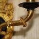 Pair of L'Originale wall sconces plated with 24-carat gold featuring four bronze candles.