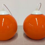 Pair of spherical pendant lights in orange opaline, France circa 1970.