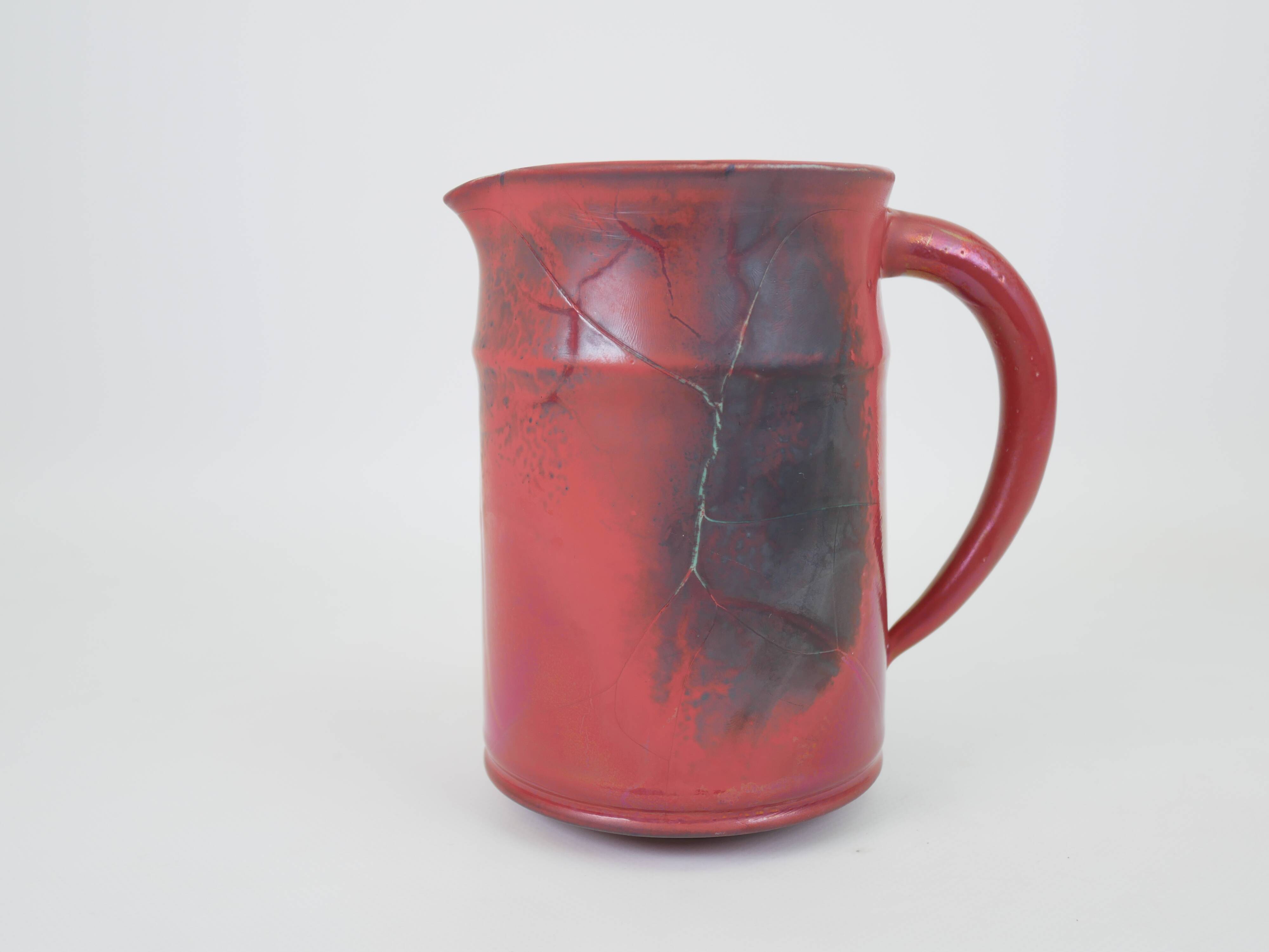 Red glazed ceramic jug with relief