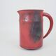 Red glazed ceramic jug with relief