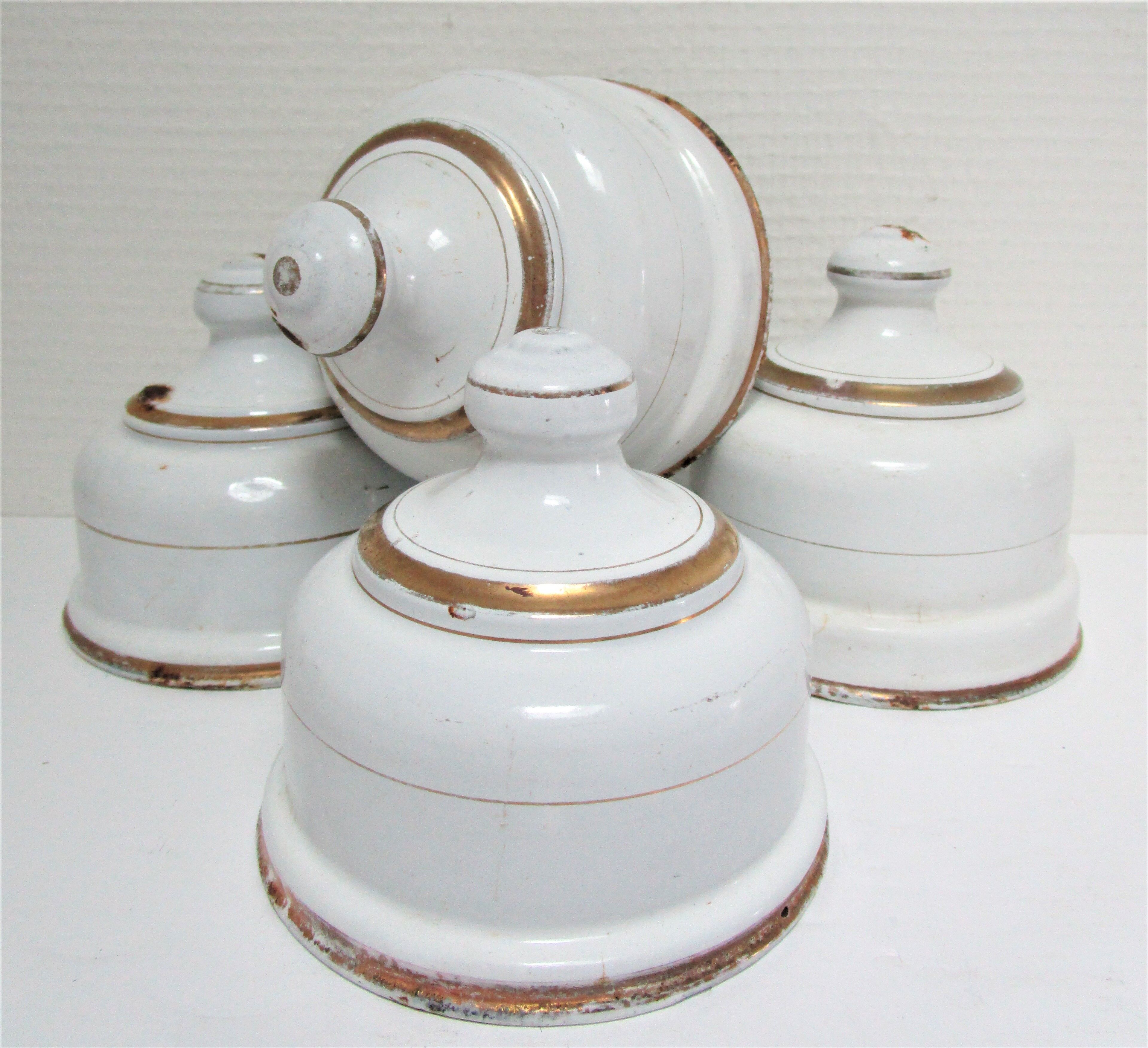 Four white enamelled metal cheese bells early twentieth century