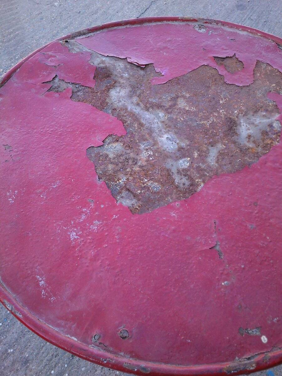 Vintage red cast iron bistro table (1950s) — round metal top, tripod base.