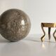 Marble ball paperweight on vintage brass