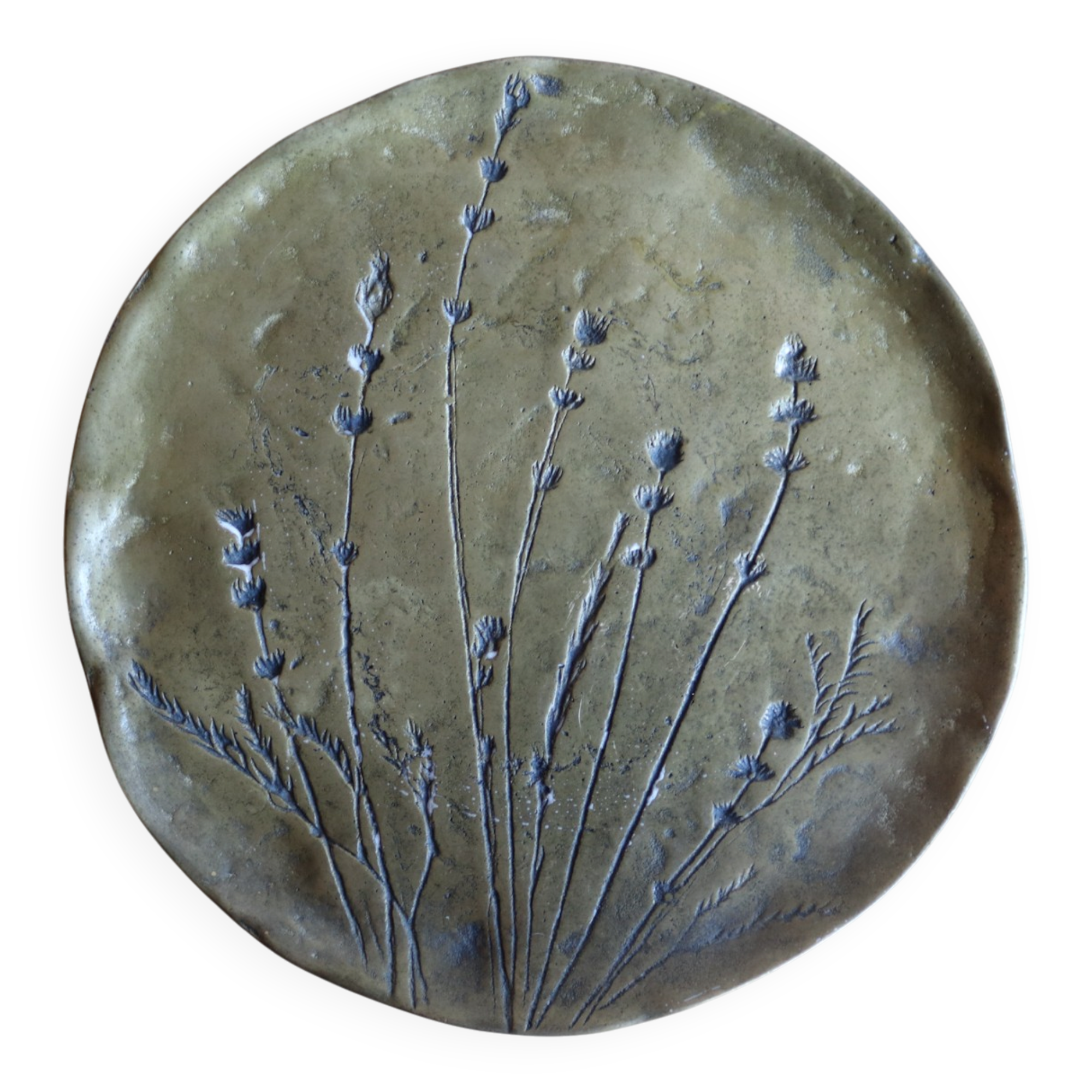 Decorative wall plaque in brass with a floral design.