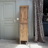 Column storage unit with a sculpted metal door.