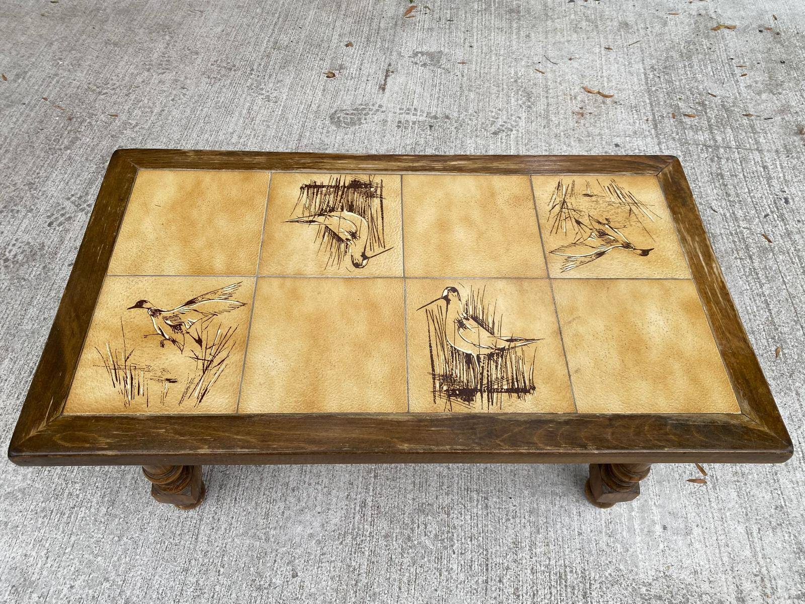 Vintage 70s coffee table with wood and ceramic tiles featuring bird and nature patterns.