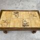 Vintage 70s coffee table with wood and ceramic tiles featuring bird and nature patterns.