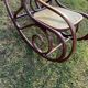 Thonet rocking chair in curved brown wood, period seat, 19th-century bentwood style.