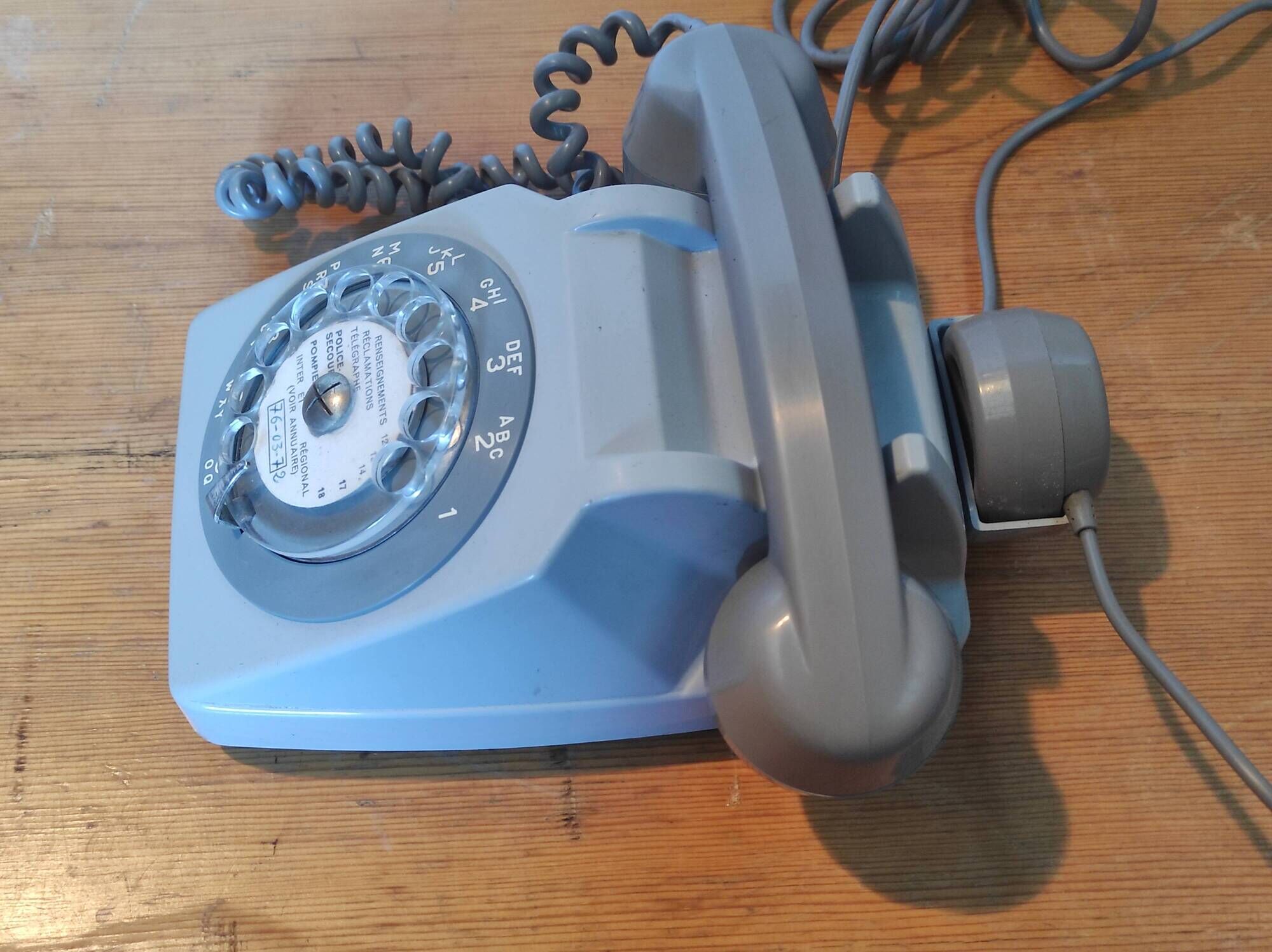 Old vintage wired dial phone with its earphone, gray color. Late 70s - early