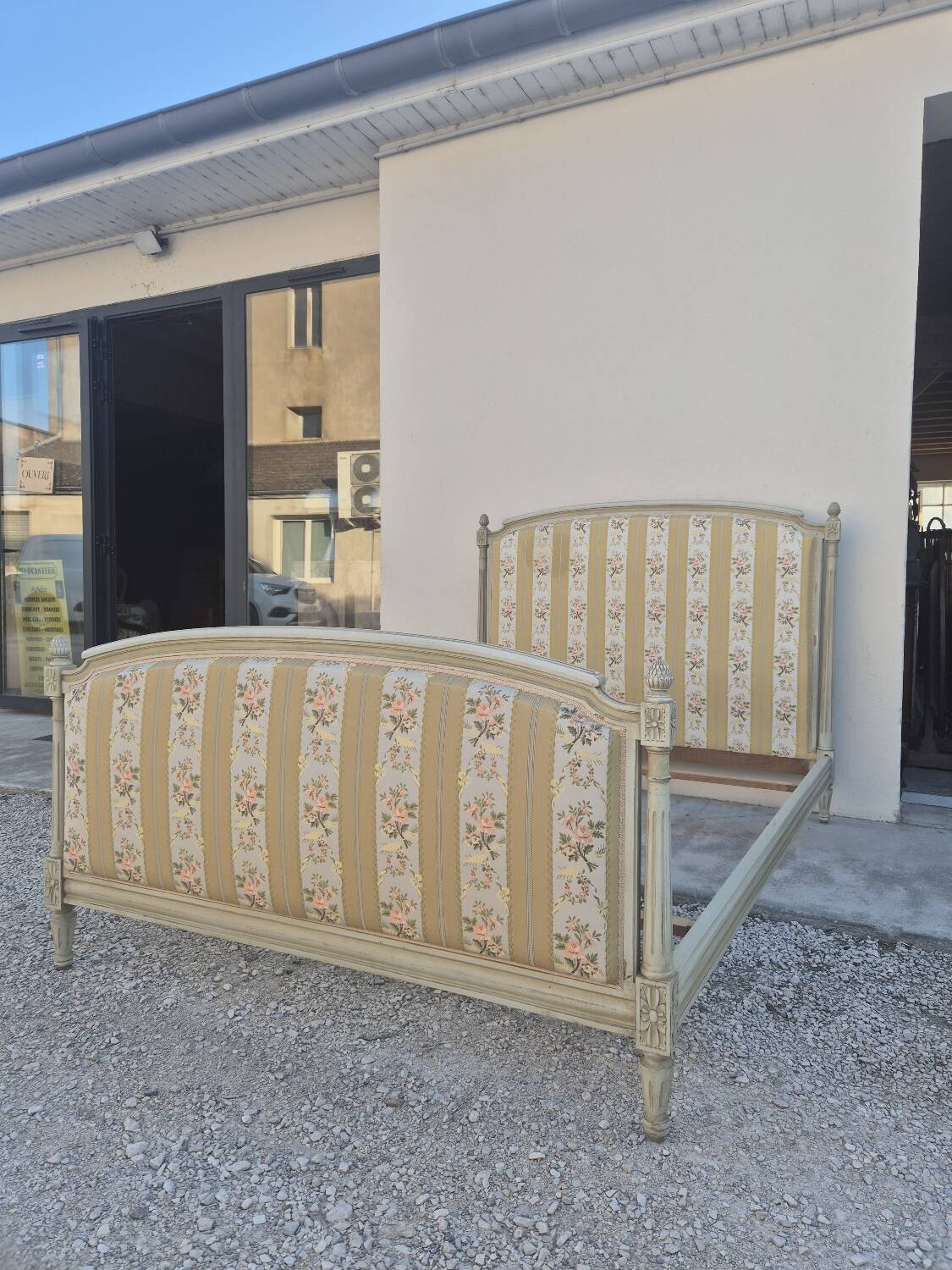 Louis XVI style bed richly decorated in patinated wood.