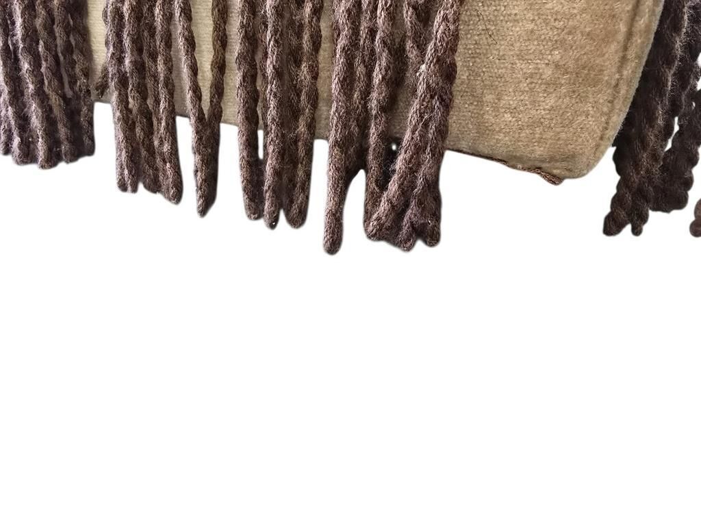 Vintage beige two-seater canapé with fringes.