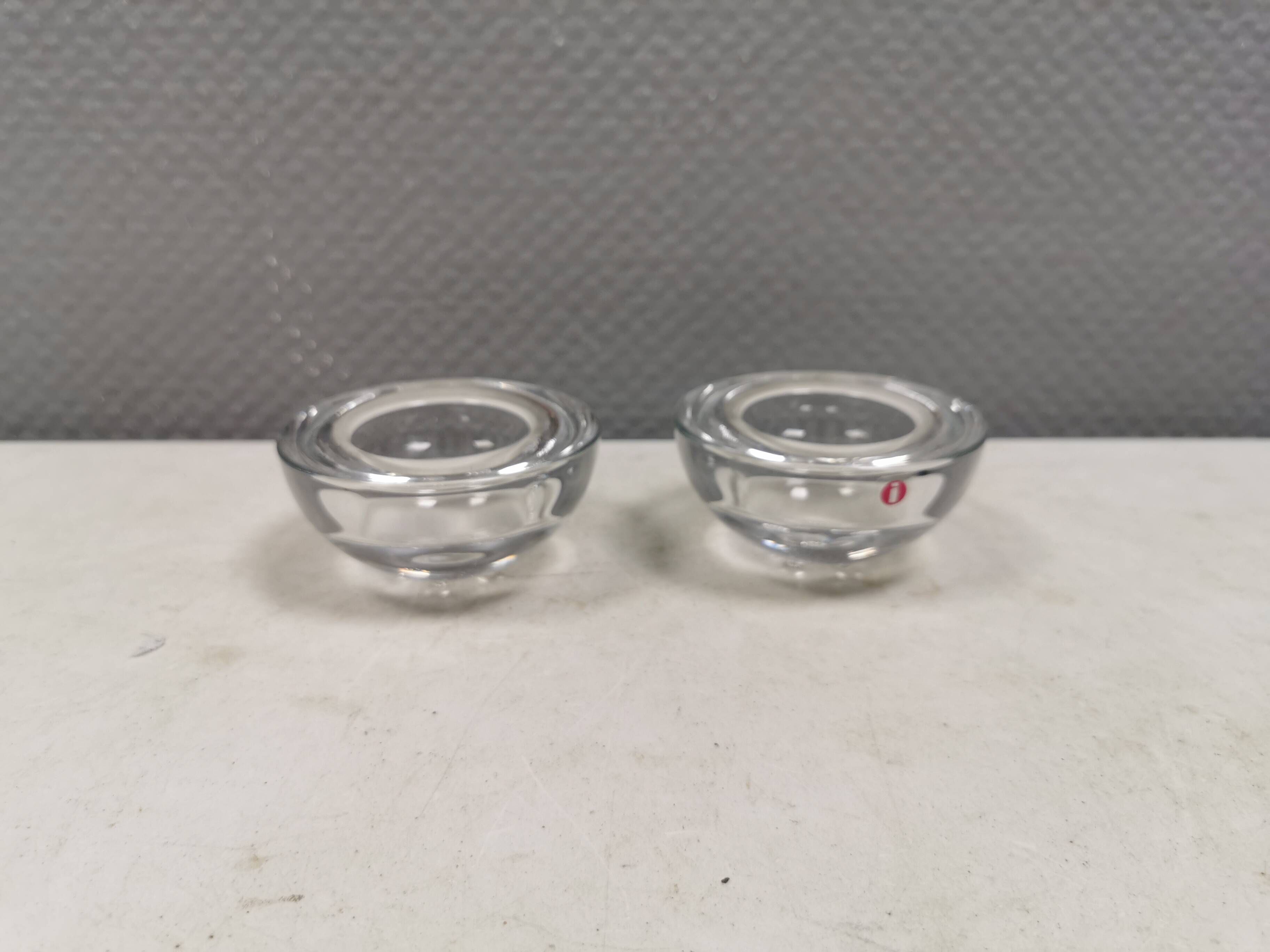 A set of iittala candle holders in clear transparent glass.