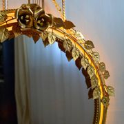 Vintage round illuminated mirror in gold metal with rose decoration.