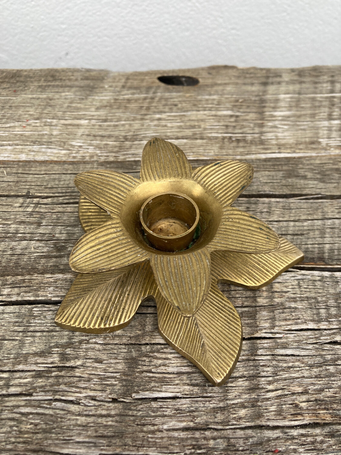 Old golden brass candle holder in the shape of a leaf or flower