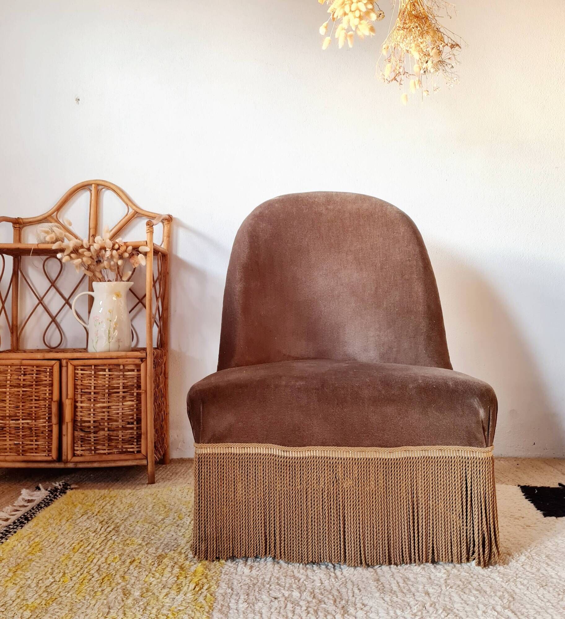Brown velvet crapaud armchair with fringes and sculpted legs.