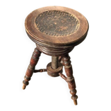 Adjustable brown leather piano stool with turned legs, produced in the 1940s.