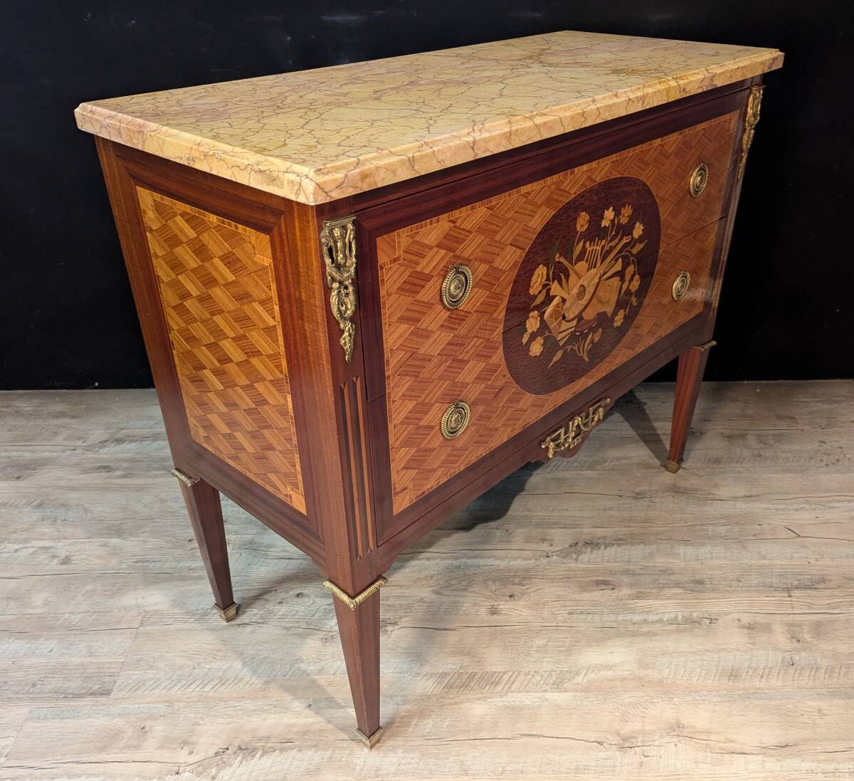 Louis XVI style commode inlaid with a decoration of instruments.