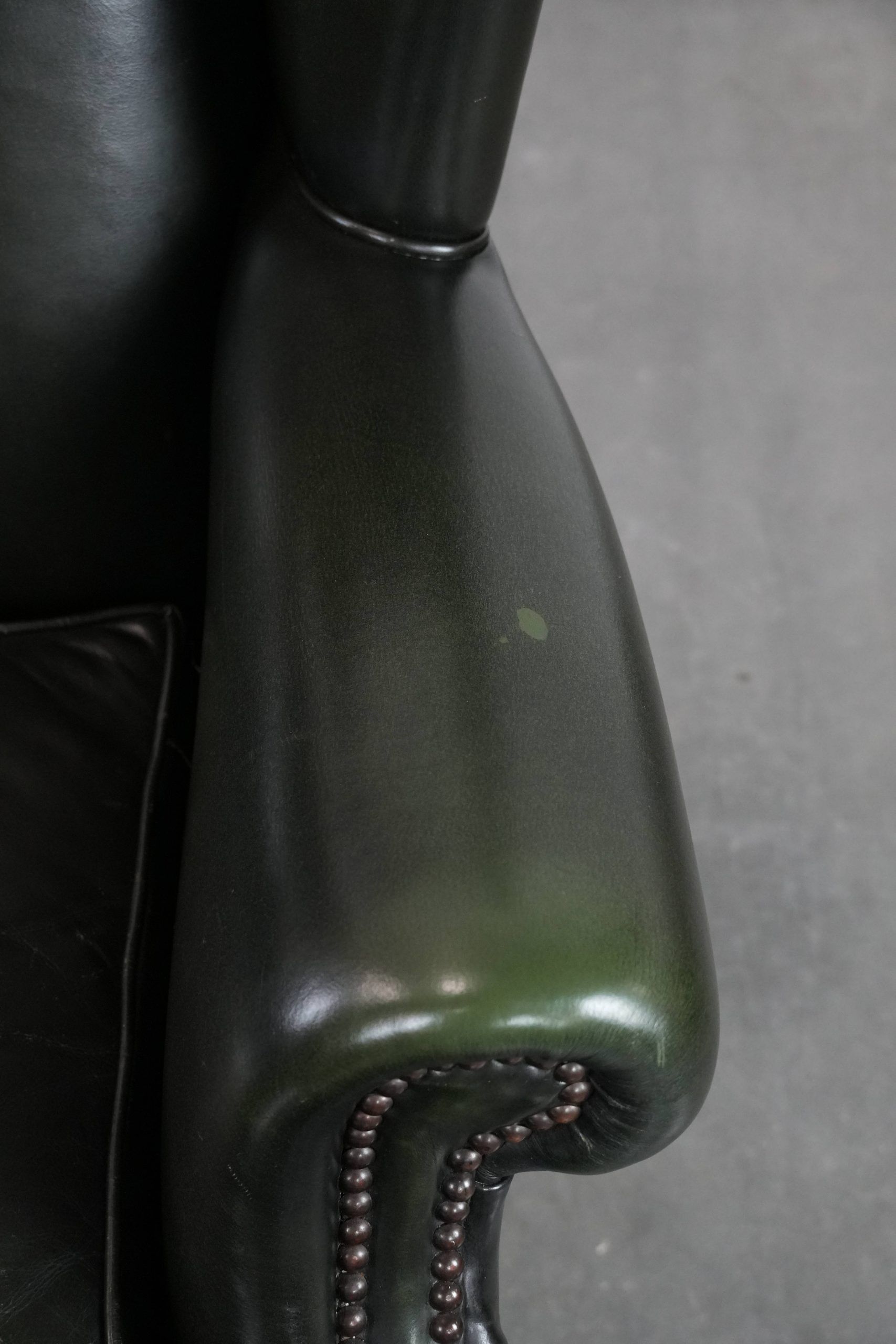 Smooth classic cowhide Chesterfield armchair in a stylish dark green color