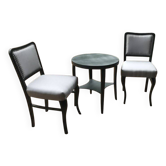 Art Deco set from the 1920s – 2 black chairs and a round brown wooden table with fabric.