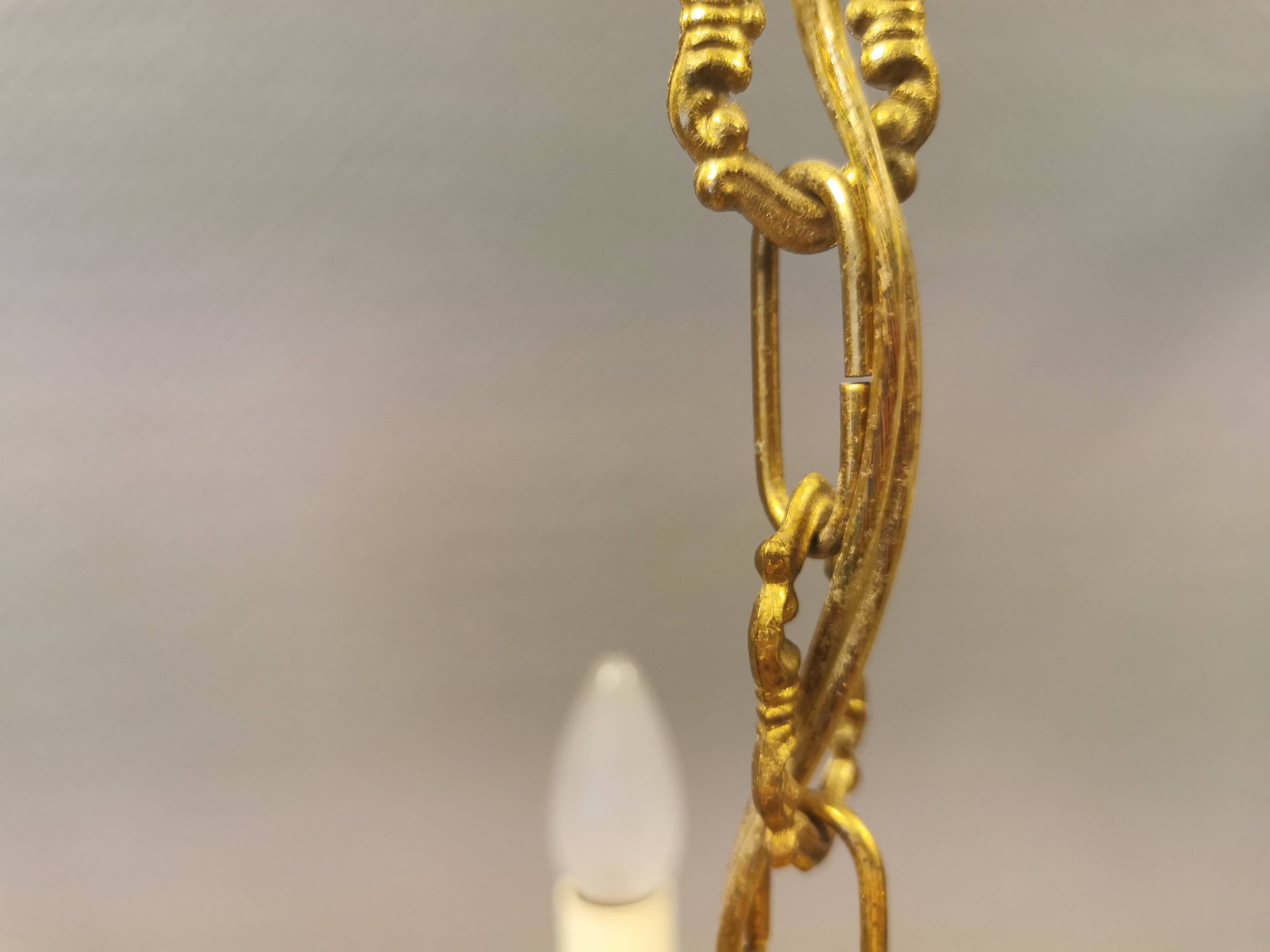 Older brass alloy chandelier with three light sources.