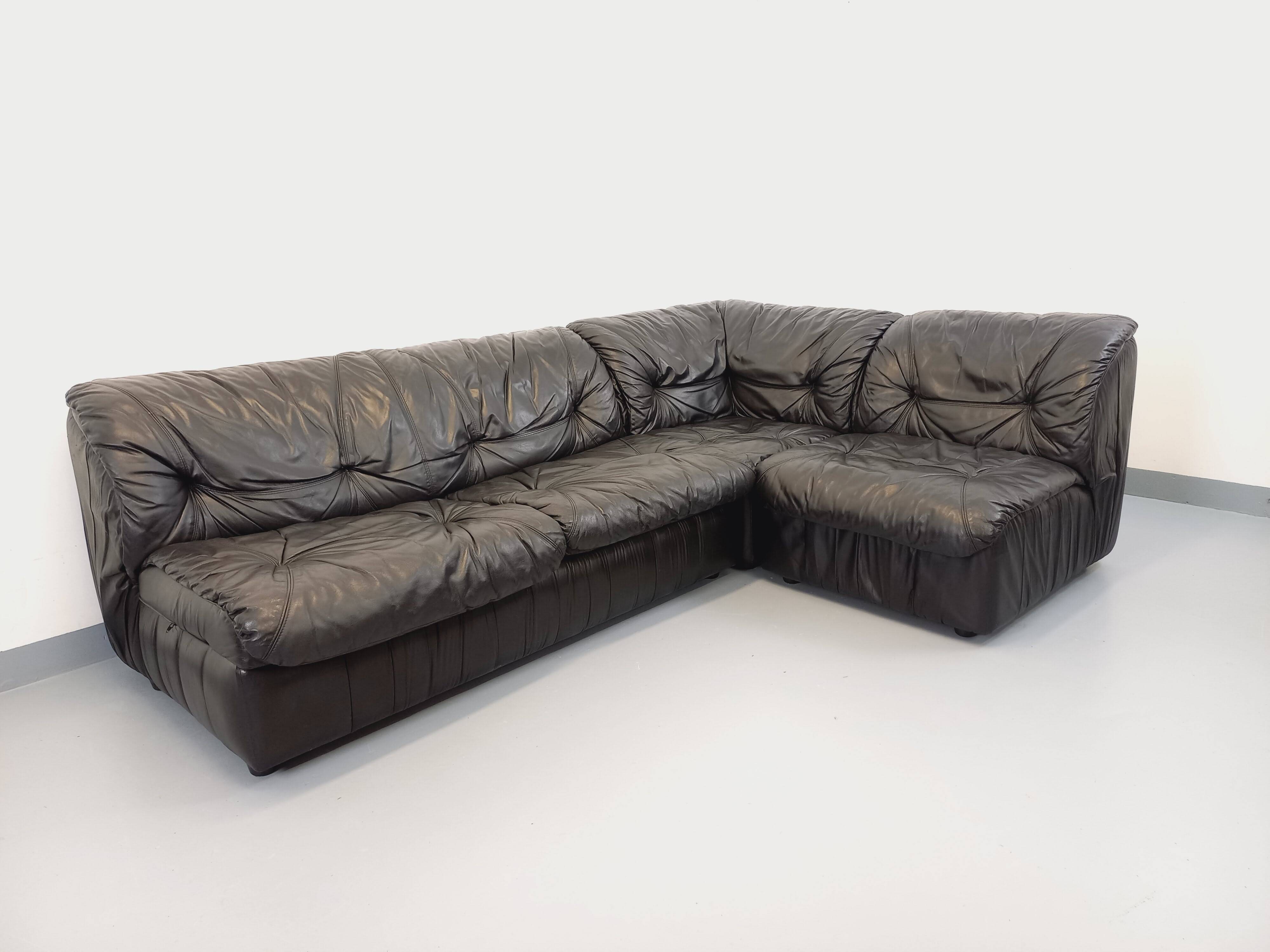 Vintage corner sofa composed of 3 modules in black leather with integrated bed.