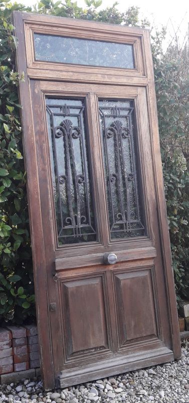 Oak entrance door and its frame and transom, wrought iron gates