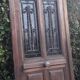 Oak entrance door and its frame and transom, wrought iron gates