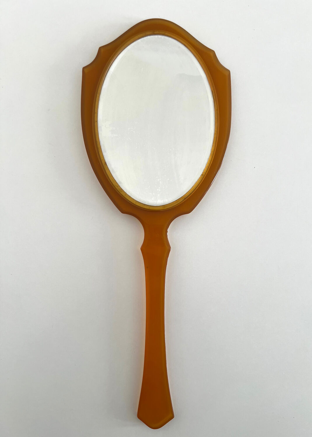Chic coral orange hand mirror with a mother-of-pearl back – elegant retro style.