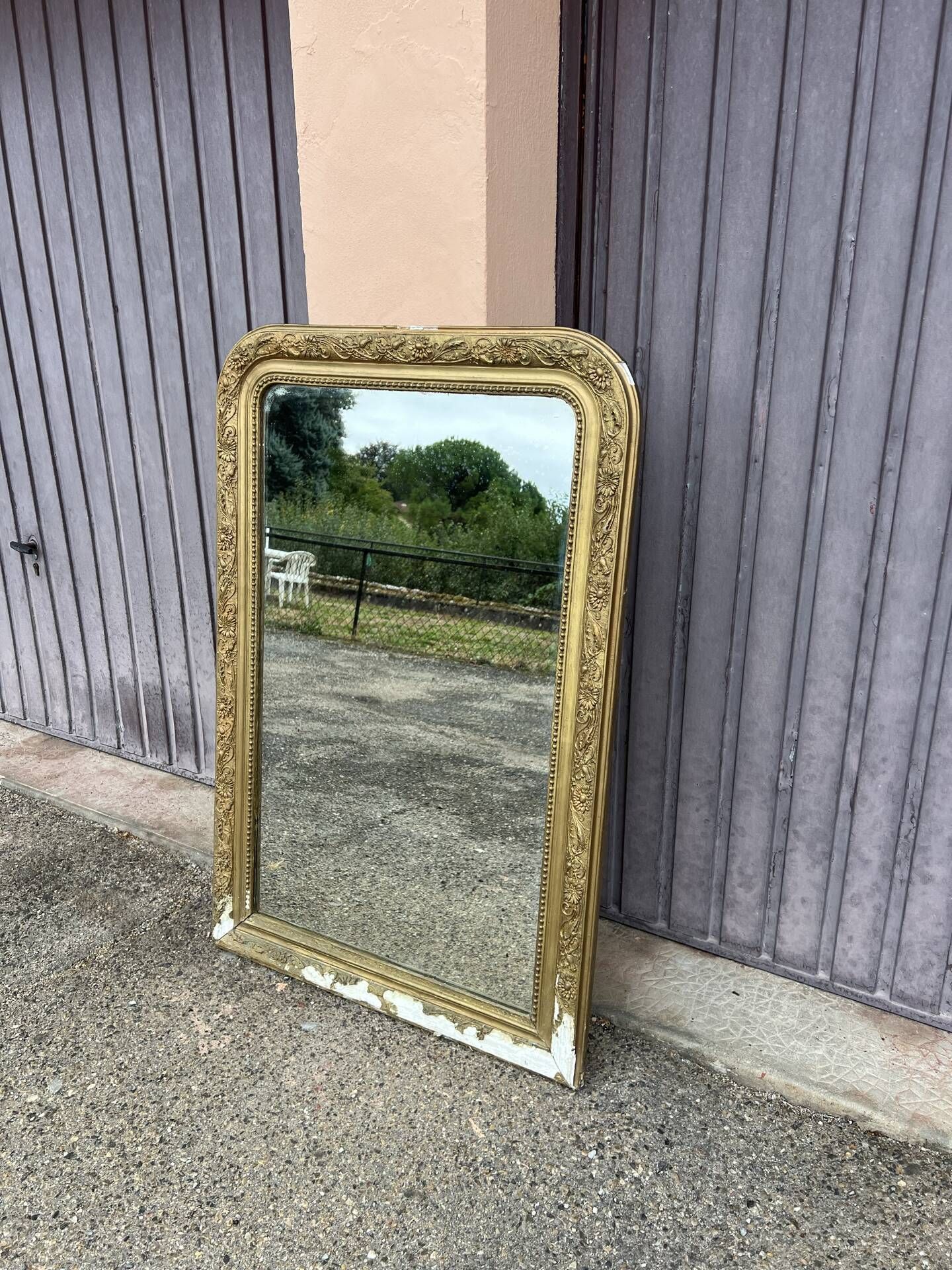 Large Louis Philippe mirror in carved gilded wood with mercury glass.