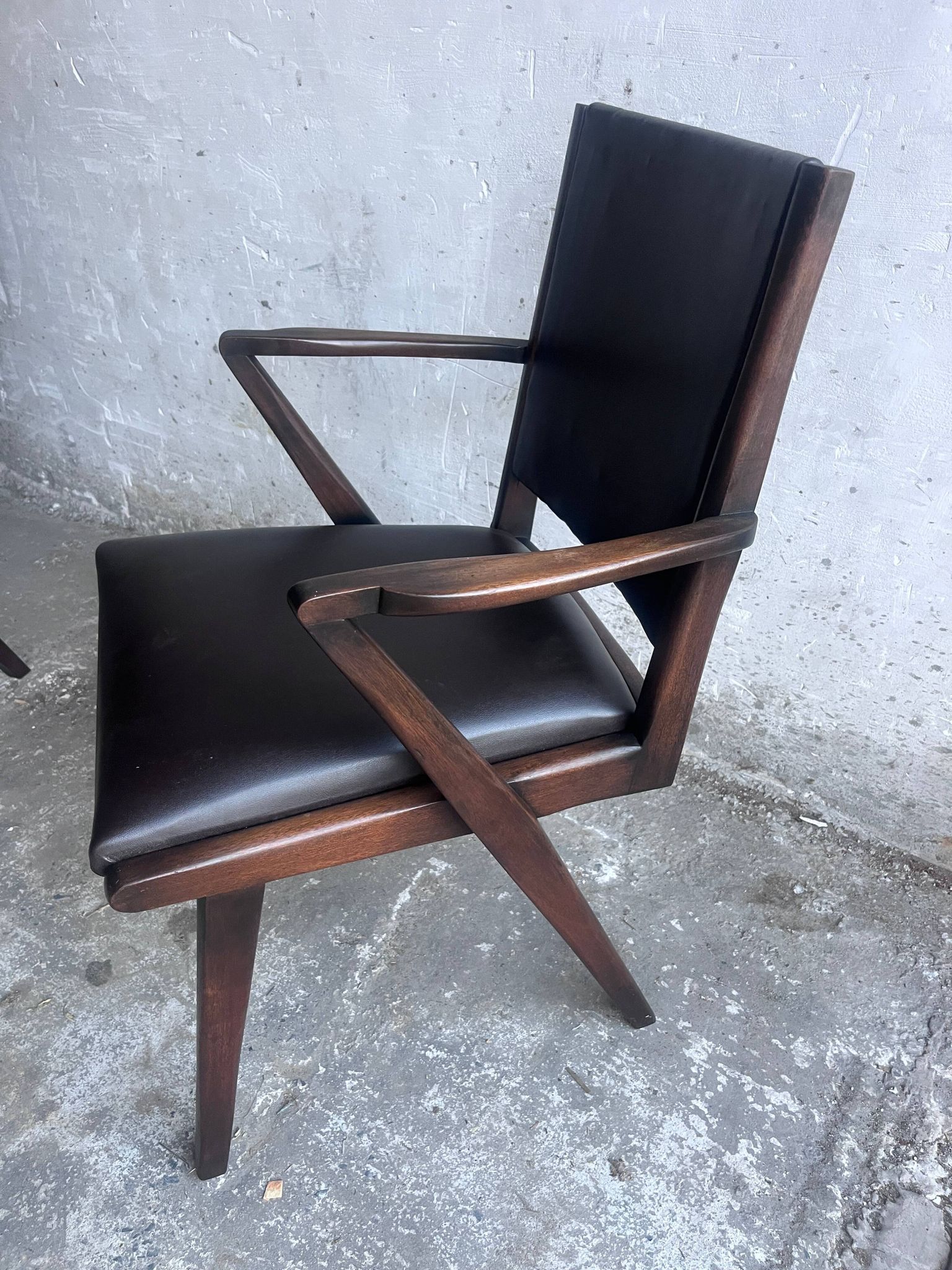 Pair of sculptural mid-century armchairs in dark wood and brown upholstery.