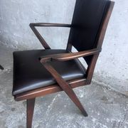 Pair of sculptural mid-century armchairs in dark wood and brown upholstery.