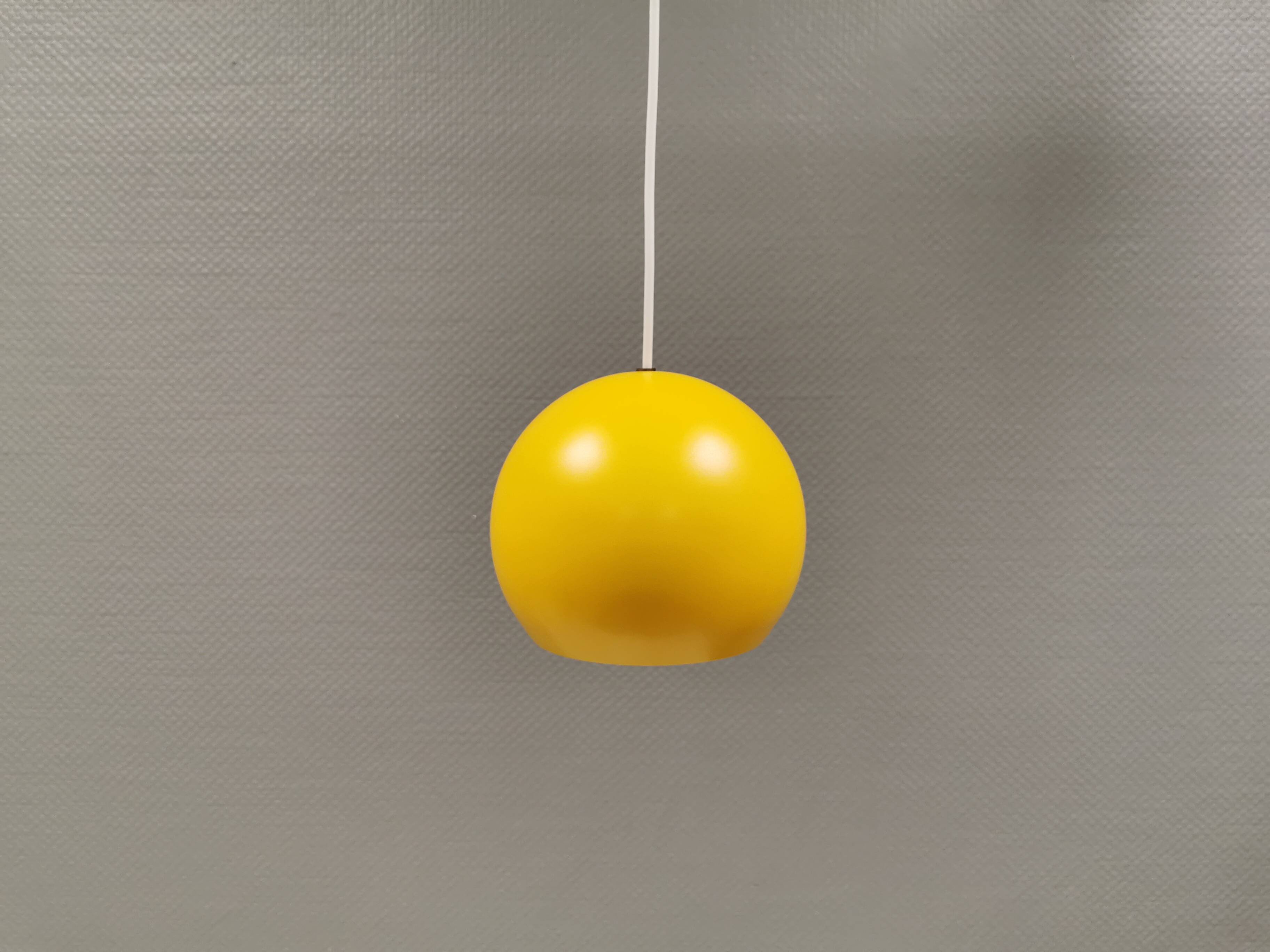 Spherical pendant lamp in sunny yellow.
