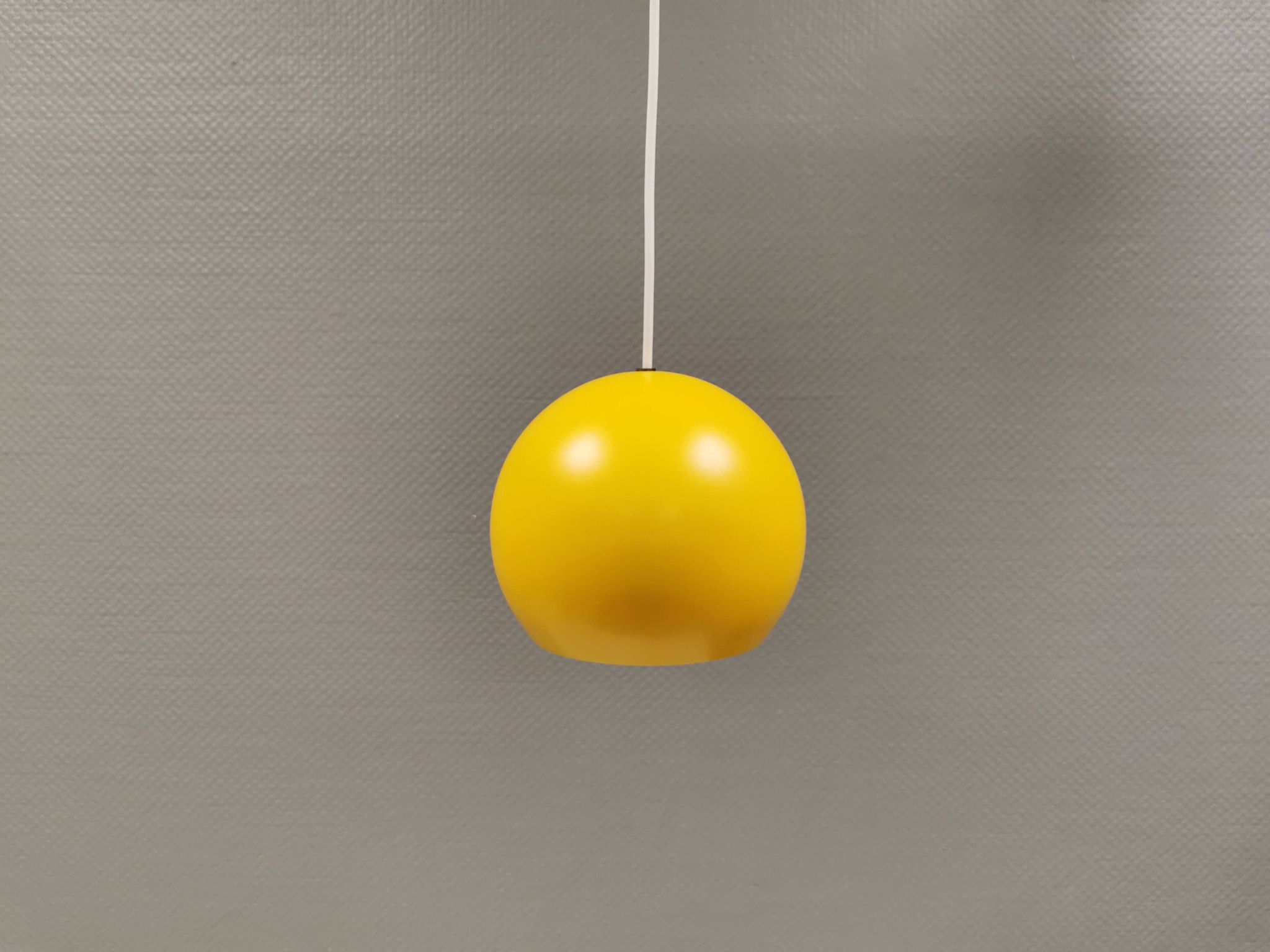 Lampe suspendue sphérique en jaune ensoleillé.