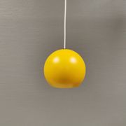Lampe suspendue sphérique en jaune ensoleillé.