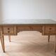 Solid wood desk with glass top and sculptures.