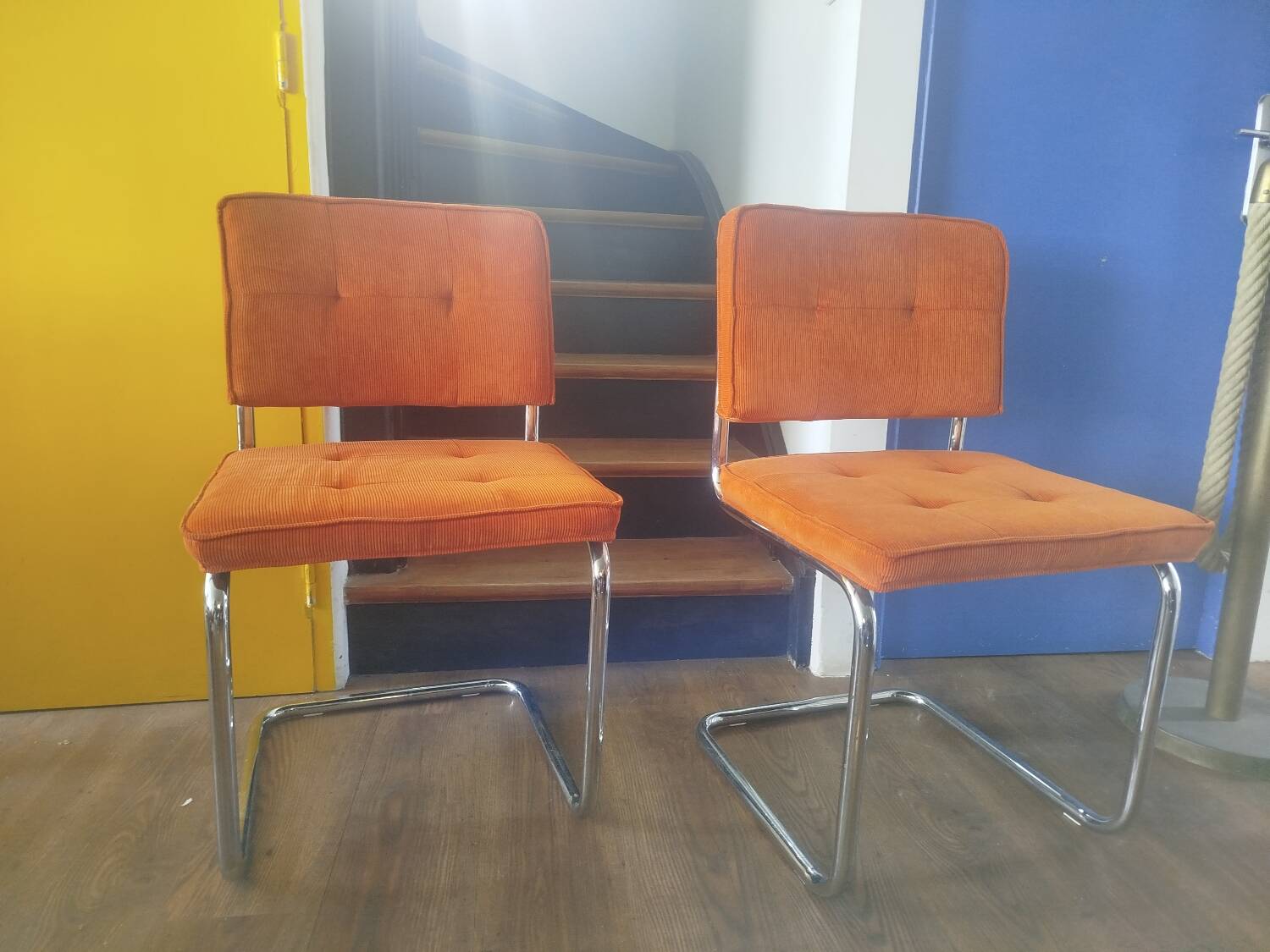 Pair of vintage cantilever chairs in chrome and orange corduroy.