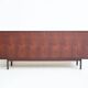 Wooden sideboard with sliding door and white drawers, around 1960.