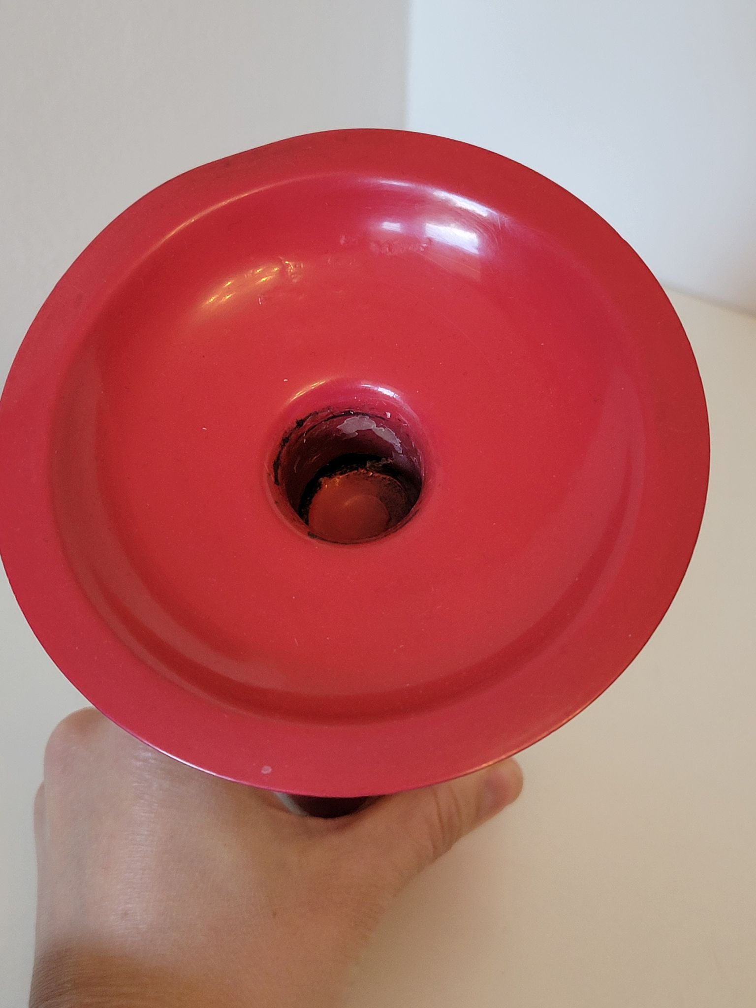 Vintage design candlestick in red metal in the shape of an hourglass