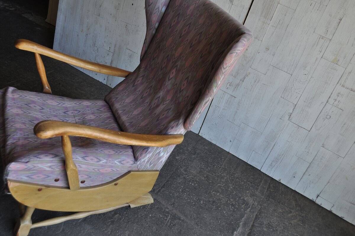 Vintage brown wooden rocking chair from the 1950s, wingback backrest and rocking base.
